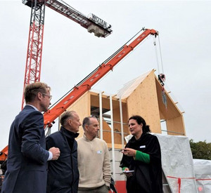 Besuch der Referenzbaustelle an der RWTH Aachen. Besuchergruppe im Gespräch. Im Hintergrund ein Kran